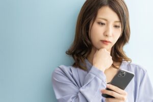 女性　悩む　スマホ